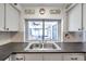 Kitchen features a stainless steel double sink and a pass-through window to an outdoor patio at 3118 Lloyd Dr, Holiday, FL 34691