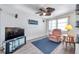 Well-lit living room with accent chair, brick wall, television and view out the window at 3118 Lloyd Dr, Holiday, FL 34691