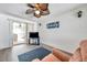 Bright living room has brick wall, television, large window, and sliding doors leading to patio at 3118 Lloyd Dr, Holiday, FL 34691