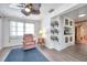 Cozy living room featuring an accent chair, decorative shelves, and light-filled window at 3118 Lloyd Dr, Holiday, FL 34691