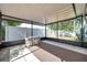 View of screened in porch featuring tile flooring, a ceiling, and an outdoor dining set at 3118 Lloyd Dr, Holiday, FL 34691