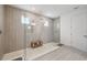 Large glass shower with a rainfall showerhead, wood bench, and a tile surround at 33466 Landsman Loop, Wesley Chapel, FL 33543