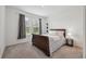 This bedroom features carpet, natural light, and a side table with lamp at 33466 Landsman Loop, Wesley Chapel, FL 33543