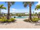 Stunning community pool area with lounge chairs, palm trees, and a sunshade, creating a resort-like experience at 33466 Landsman Loop, Wesley Chapel, FL 33543