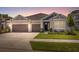 Charming single-story home featuring a well-manicured lawn, two-car garage, and neutral-toned exterior at 33466 Landsman Loop, Wesley Chapel, FL 33543
