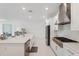 Open-concept kitchen with stainless steel appliances, white cabinets, and spacious island with modern fixtures at 33466 Landsman Loop, Wesley Chapel, FL 33543