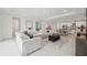 Open-concept living room with white couch, black coffee table, and view of modern kitchen and dining areas at 33466 Landsman Loop, Wesley Chapel, FL 33543