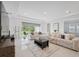 Spacious living room with comfortable seating, a modern rug, and sliding glass doors to the backyard at 33466 Landsman Loop, Wesley Chapel, FL 33543