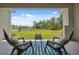 Covered patio with chairs and a view of the landscaped backyard at 33466 Landsman Loop, Wesley Chapel, FL 33543