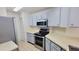 View of the galley kitchen with stainless steel appliances and light-colored cabinets at 4015 Angel Oak Ct # 201, Tampa, FL 33613