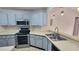 Kitchen area with modern appliances, updated cabinets, and a stainless-steel sink at 4015 Angel Oak Ct # 201, Tampa, FL 33613