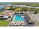 A beautiful aerial view showcases a community pool, clubhouse, and tennis courts with a scenic waterfront backdrop at 4052 Marine Pkwy, New Port Richey, FL 34652