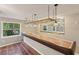 Custom home bar with tiled countertop, overhead glass rack, and view to landscaped exterior at 4052 Marine Pkwy, New Port Richey, FL 34652