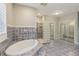 Bathroom featuring a large soaking tub, separate shower with glass block, and tile accents at 4052 Marine Pkwy, New Port Richey, FL 34652