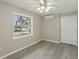 This bedroom features new floors, a ceiling fan, and a bright window at 4052 Marine Pkwy, New Port Richey, FL 34652