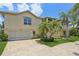 Spacious home with a two-car garage, stone driveway, and mature landscaping at 4052 Marine Pkwy, New Port Richey, FL 34652