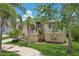 Inviting two-story home showcasing a well-maintained lawn, mature trees, and a classic architectural design at 4052 Marine Pkwy, New Port Richey, FL 34652