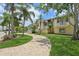 Charming home featuring lush landscaping, a paver driveway, and a welcoming facade under a sunny sky at 4052 Marine Pkwy, New Port Richey, FL 34652