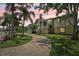 Attractive two-story home featuring lush landscaping, palm trees, and a curved brick driveway at 4052 Marine Pkwy, New Port Richey, FL 34652
