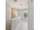 Upstairs hallway with decorative chandelier, a window, and tile flooring at 4052 Marine Pkwy, New Port Richey, FL 34652
