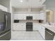 Modern kitchen with white cabinetry, stainless steel appliances, and tile flooring at 4052 Marine Pkwy, New Port Richey, FL 34652