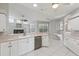 Bright kitchen boasts white cabinets, stainless appliances, and view of the living area, perfect for entertaining at 4052 Marine Pkwy, New Port Richey, FL 34652
