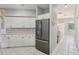 Bright kitchen features stainless steel appliances, white cabinets and tile floors at 4052 Marine Pkwy, New Port Richey, FL 34652