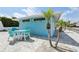 Outdoor seating area with table and chairs next to palms, and a modern turquoise building at 4052 Marine Pkwy, New Port Richey, FL 34652