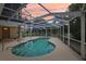 Inviting screened-in pool with spiral staircase and clear view of the lush backyard and colorful sky at 4052 Marine Pkwy, New Port Richey, FL 34652