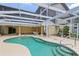 Relaxing screened-in pool area featuring a spiral staircase, tile accents, and access to the home at 4052 Marine Pkwy, New Port Richey, FL 34652