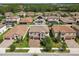 Scenic aerial view of the property with lush green surroundings, a tile roof, and a paved driveway at 4083 Woods Rider Loop, Odessa, FL 33556