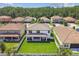 An open backyard features a large grassy area, covered patio, and fenced in yard, with surrounding trees at 4083 Woods Rider Loop, Odessa, FL 33556
