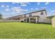 Large backyard with well-maintained lawn, covered patio, and privacy fence, ideal for outdoor gatherings at 4083 Woods Rider Loop, Odessa, FL 33556