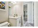 Bathroom with a white cabinet and marble countertop with a mirror, artwork, and gray wood tile at 4083 Woods Rider Loop, Odessa, FL 33556