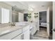 Bright bathroom with double sinks, white cabinets, tile floors, and an ensuite bedroom at 4083 Woods Rider Loop, Odessa, FL 33556