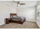 Neutral bedroom featuring a ceiling fan, carpet, and a dark wood bed with a cozy plaid blanket at 4083 Woods Rider Loop, Odessa, FL 33556