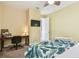 Comfortable bedroom featuring a desk area, TV, desk and queen-sized bed with a ceiling fan at 4083 Woods Rider Loop, Odessa, FL 33556