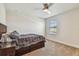 Cozy bedroom with a plaid bedspread, ceiling fan, and ample natural light at 4083 Woods Rider Loop, Odessa, FL 33556