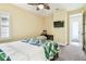 Bright bedroom with a desk area, TV, yellow walls, wood ceiling fan and king size bed at 4083 Woods Rider Loop, Odessa, FL 33556