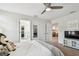 Bedroom features neutral tones, ceiling fan, television, and ensuite bathroom at 4083 Woods Rider Loop, Odessa, FL 33556