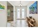 Inviting entryway with decorative art, wood-look tile flooring, and frosted double doors for added privacy and style at 4083 Woods Rider Loop, Odessa, FL 33556