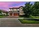 Charming two-story home with stone details, a three-car garage, and a lush front lawn at 4083 Woods Rider Loop, Odessa, FL 33556