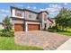 Stunning two-story home boasts stone accents, a three-car garage, and a brick paved driveway at 4083 Woods Rider Loop, Odessa, FL 33556