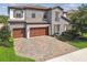 Stunning two-story home featuring a stone facade, three-car garage, and manicured landscaping for curb appeal at 4083 Woods Rider Loop, Odessa, FL 33556