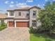 Beautiful two-story home showcasing a stone exterior, three-car garage, and well-maintained front yard landscaping at 4083 Woods Rider Loop, Odessa, FL 33556