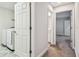 Hallway with laundry area and bathroom access showcases neutral tones and clean design at 4083 Woods Rider Loop, Odessa, FL 33556