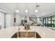 Kitchen island features a sink with an open layout and seamless flow into the living and dining area at 4083 Woods Rider Loop, Odessa, FL 33556