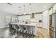 Stylish kitchen with white cabinets, stainless steel appliances, kitchen island and barstool seating for guests at 4083 Woods Rider Loop, Odessa, FL 33556