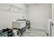 Functional laundry room features tile floors, utility sink, shelving and modern washer/dryer at 4083 Woods Rider Loop, Odessa, FL 33556