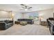 Comfortable living room with a ceiling fan, comfortable seating, desk and carpeted floors at 4083 Woods Rider Loop, Odessa, FL 33556